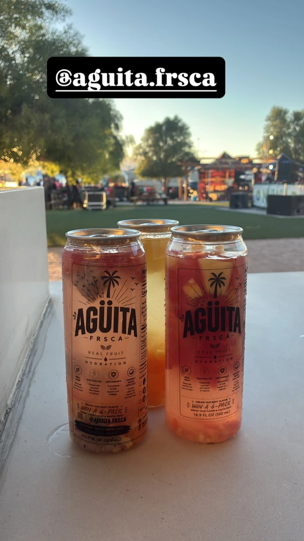 Three Agüita FRSCA drinks at an outdoor community gathering