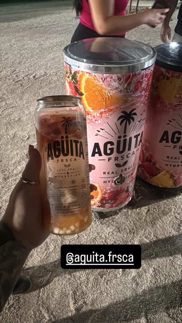 A fruit-filled Agüita FRSCA can beside the brand’s event drink dispenser