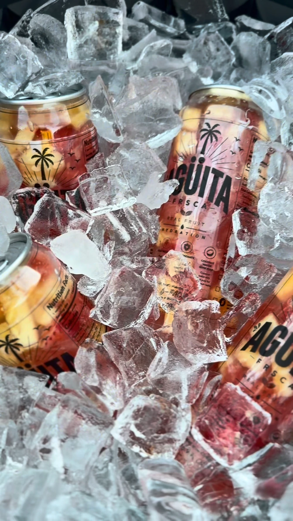 Agüita FRSCA fruit-filled cans nestled in ice, photographed by the brand