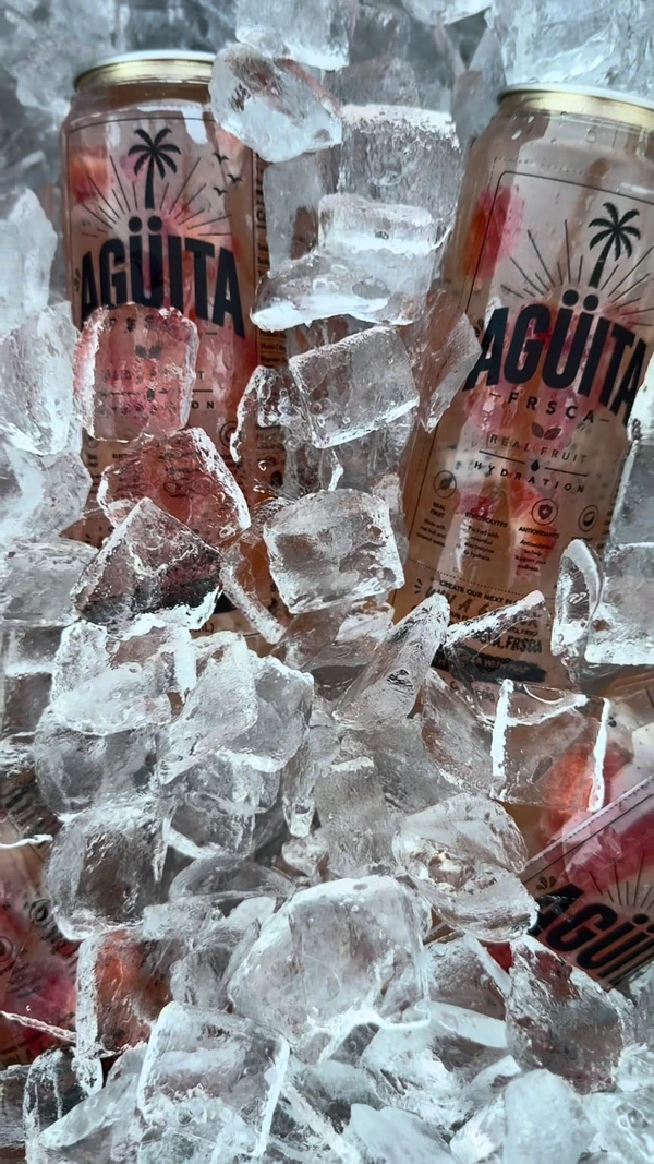 Pink Agüita FRSCA cans surrounded by ice