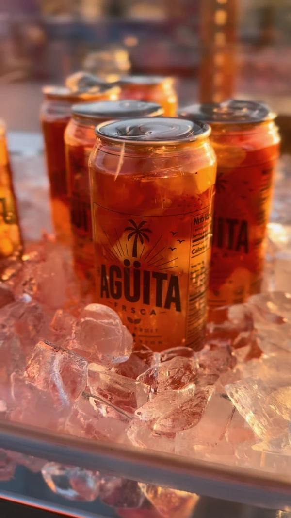 Red fruit-filled Agüita FRSCA cans chilled on ice